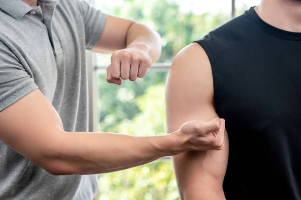 terapeuta dando masaje a paciente masculino de atleta por golpeando y golpeando - massaging men swedish culture male fotografías e imágenes de stock