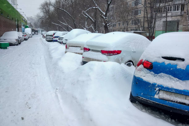 ośnieżone ows samochodów na parkingu. scena miejska, śnieżyca. zaspy na drodze i parkingu. - street snow urban scene residential district zdjęcia i obrazy z banku zdjęć