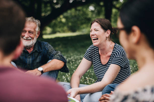 femme joyeuse dans le parc avec ses amis - people activity behavior smiling photos et images de collection