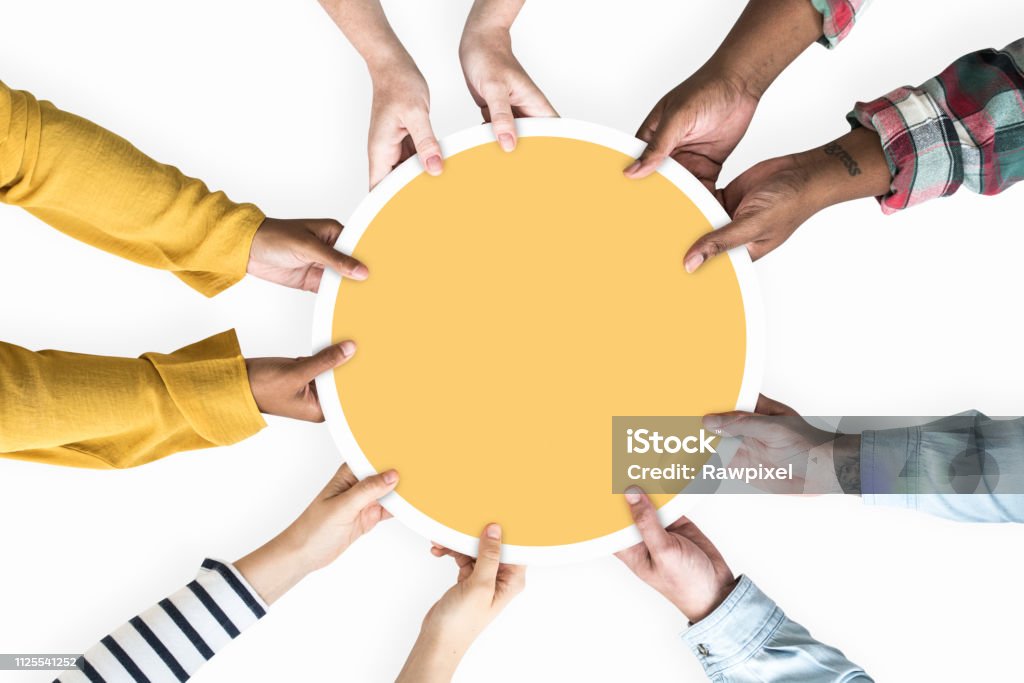 Diverse Hände unterstützen eine leere gelbe Runde board - Lizenzfrei Zusammenarbeit Stock-Foto