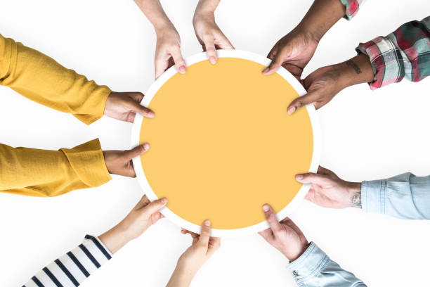 Diverse hands supporting a blank yellow round board Diverse hands supporting a blank yellow round board charitable giving stock pictures, royalty-free photos & images