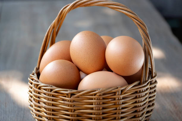 istock Fresh eggs are in a wicker basket on a wood table. 1125541853