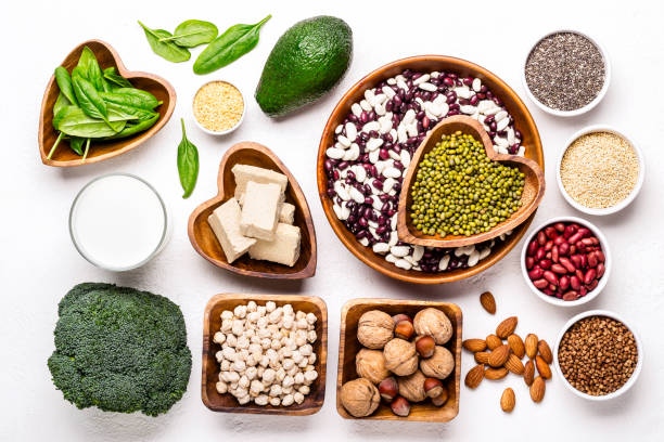 istock selection of vegetable protein sources. Beans, broccoli, spinach, nuts with bowls 1125541945