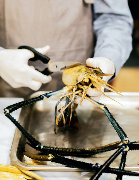 istock chef cooking seafood, Hand cutting raw black tiger prawn 1125547735