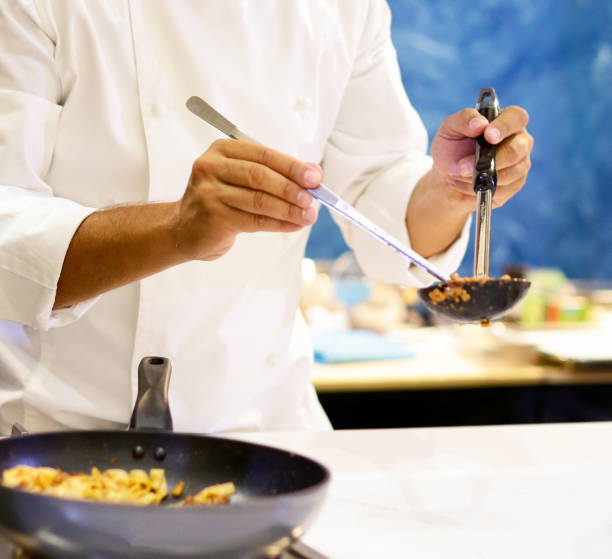 istock Chef cooking pasta, Chef serves spaghetti carbonara on the plate in the kitchen 1125547773