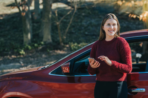 istock Young woman outside the car using smartphone 1125548085
