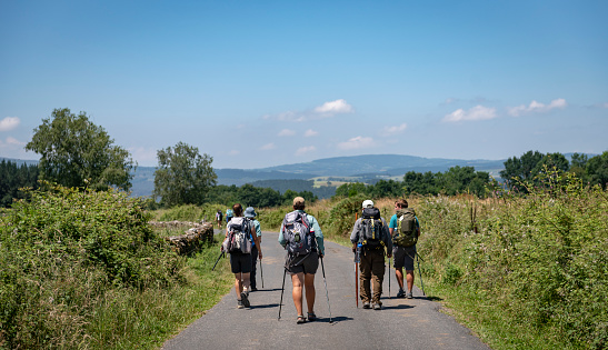 A group of pilgrims walk down a country road that is part of the Camino de Santiago near Portomarin, Spain (July 7, 2018)