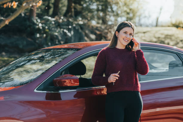 istock Young woman outside the car using smartphone 1125548345