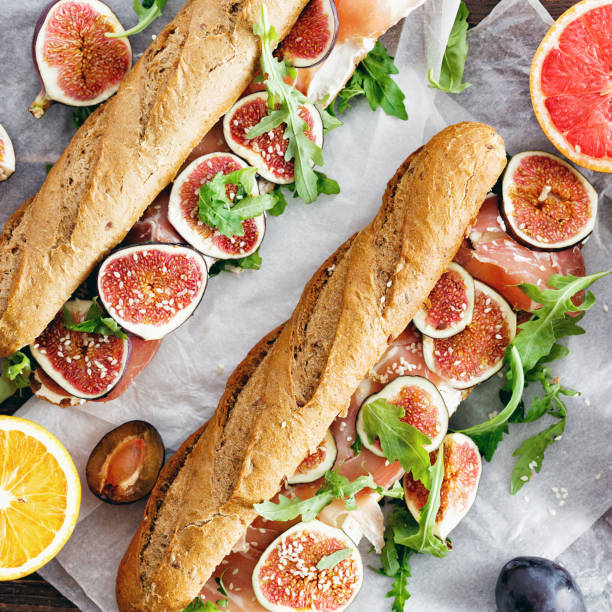 Sandwich with prosciutto, mascarpone cheese and figs on wooden table top view