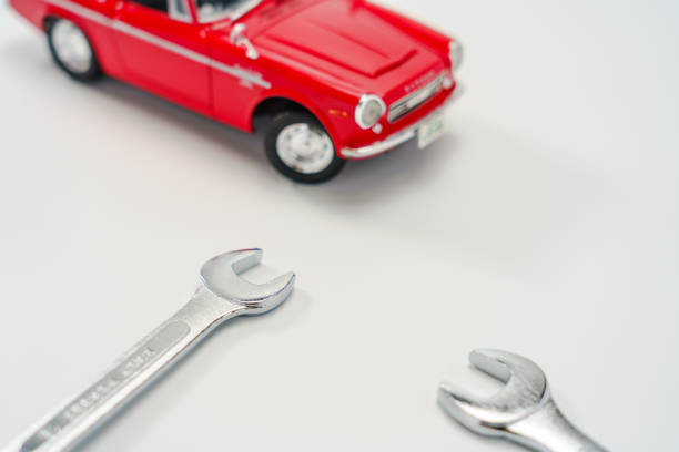 Spanner and car toys on white background
