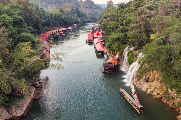 bateau en bois voilier rivière kwai avec chute d’eau dans la forêt tropicale - national park kanchanaburi province thailand waterfall photos et images de collection