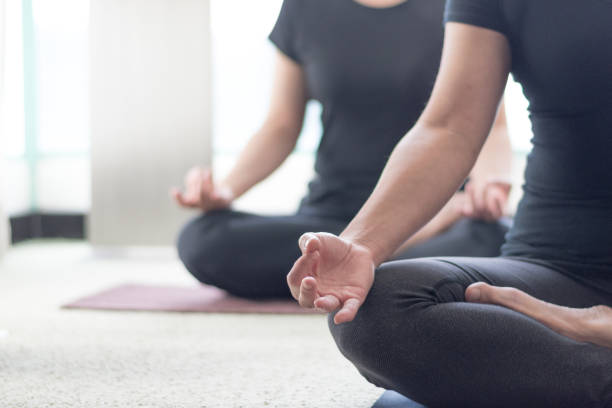 class of yoga with meditate hands of asia woman doing meditation in sunrise and lens flair effect.healthcare, lifestyle concept.national physical fitness and sports month.national yoga awareness month - 2586 imagens e fotografias de stock