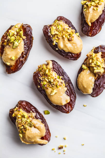 istock Dates stuffed with peanut butter and pistachios on white background. 1125565514