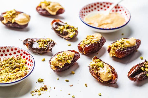 istock Dates stuffed with peanut butter, chocolate and pistachios on white background. 1125565592