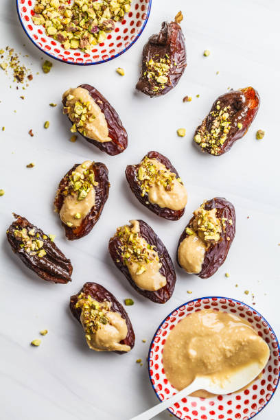 istock Dates stuffed with peanut butter, chocolate and pistachios on white background. 1125565593