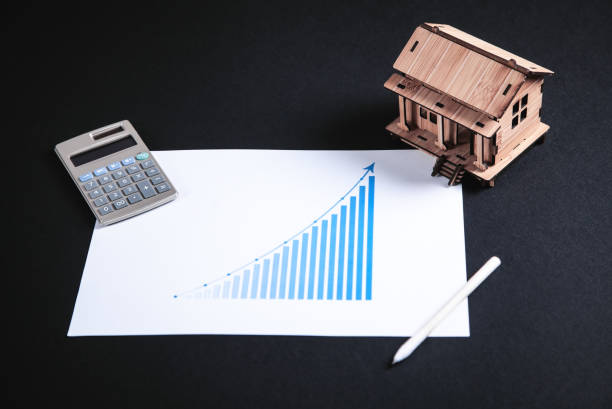 istock Wooden house model with calculator and pen. 1125565606