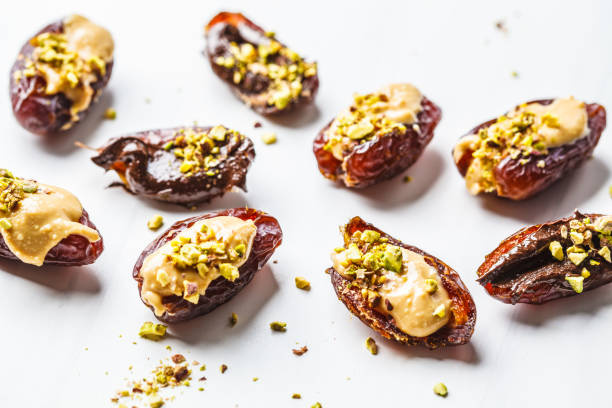 istock Dates stuffed with peanut butter, chocolate and pistachios on white background. 1125565630