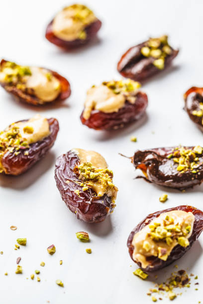 istock Dates stuffed with peanut butter, chocolate and pistachios on white background. 1125565663