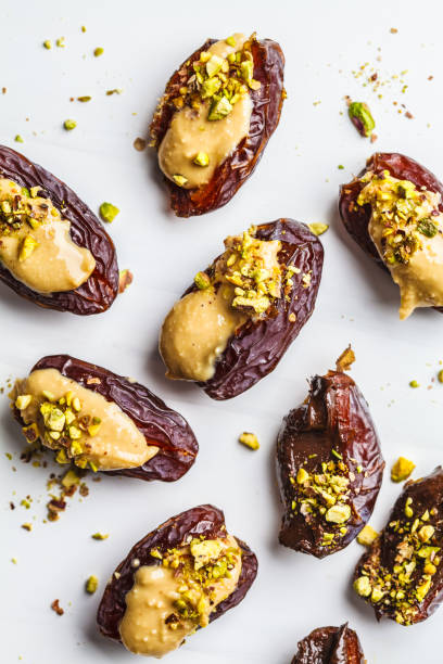 istock Dates stuffed with peanut butter, chocolate and pistachios on white background. 1125565742
