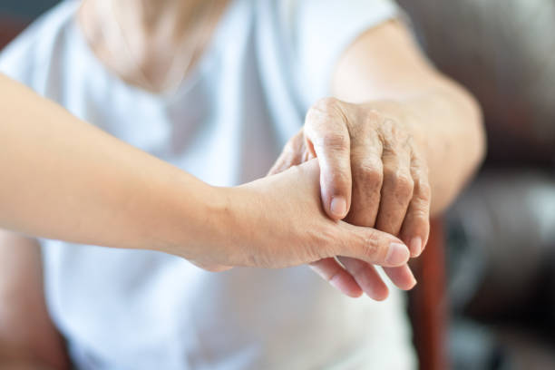starsza kobieta trzyma rękę młodego opiekuna w domu opieki. geriatryczny lekarz lub geriatryczny koncepcji. lekarz ręka lekarza na szczęśliwy starszy starszy chory na pocieszenie w badaniu szpitalnym - therapy physical impairment disabled senior adult zdjęcia i obrazy z banku zdjęć