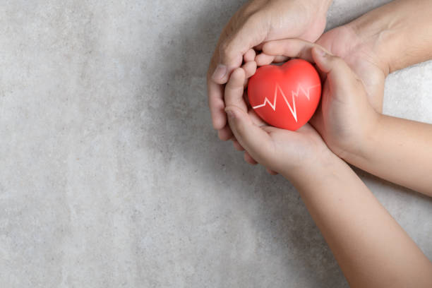 istock Father and child hands holding red heart on marble 1125570423