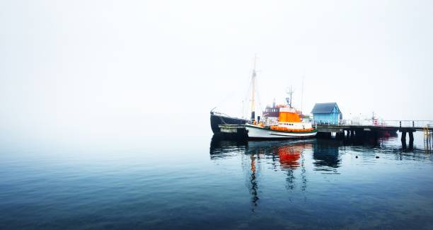 istock A pier with small boats under fog 1125571019