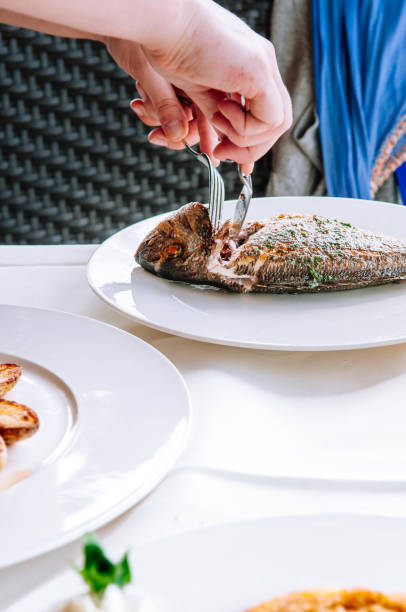 istock Woman carving grilled fish from its bones 1125571237