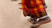 dirty bare feet of tribal female dancer in saree with anklet in tribal dance pose stance on ground