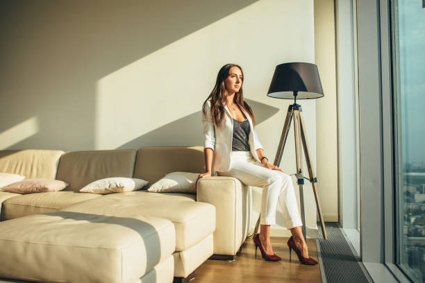 istock Woman sitting on a sofa at modern apartment 1125572391
