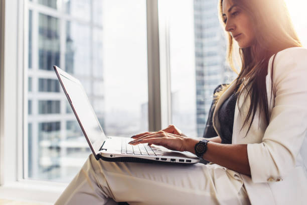 istock Young woman working on laptop sitting at home 1125572397