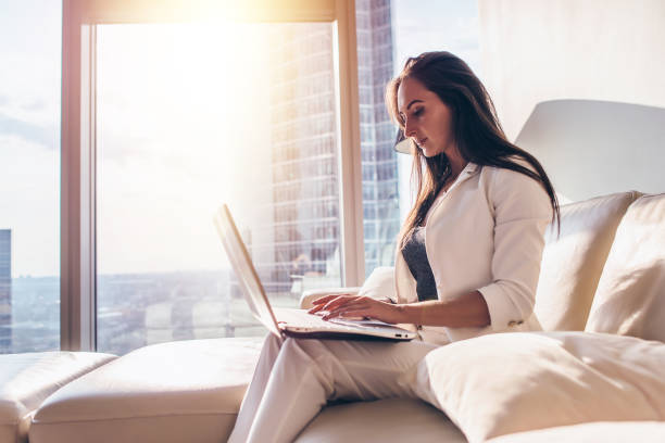 istock Side view of young woman working on laptop 1125572424