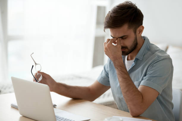 istock Stressed fatigued young man taking off glasses feeling eyestrain headache 1125572515