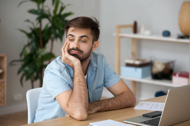istock Tired worker wasting time at workplace distracted from boring job 1125572531