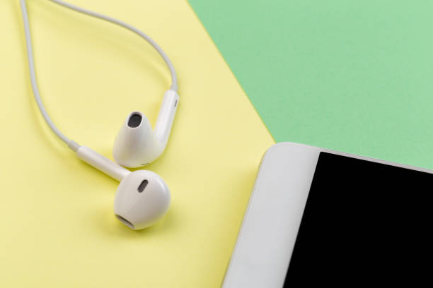 istock white earphones with phone on colour background 1125572689