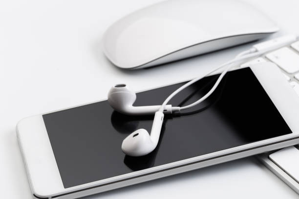 istock white earphones on white keyboard with phone 1125572692