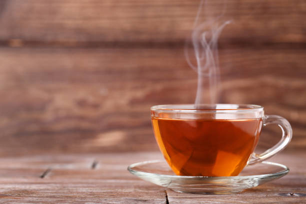 istock Cup of tea with steam on brown wooden table 1125573183