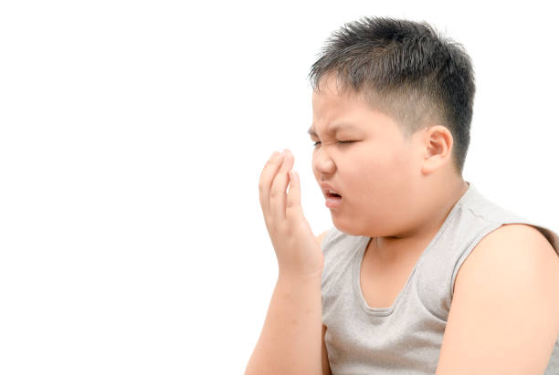 istock Obese fat boy checking his breath with his hand isolated 1125575636