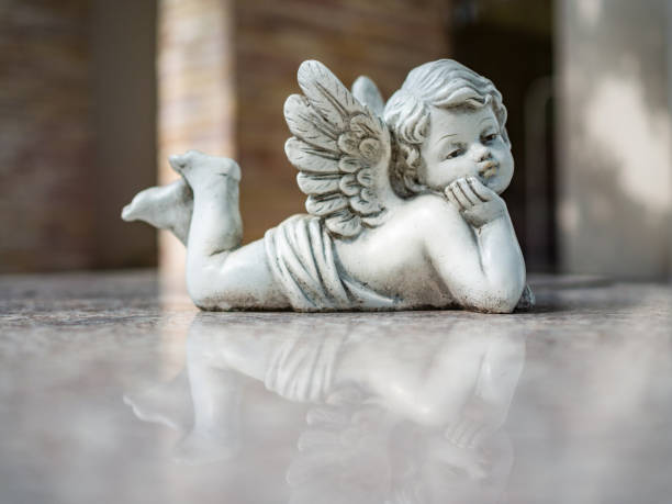 filtre vintage sur la sculpture cupidon bouchent - statue angel marble white photos et images de collection