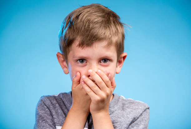 istock Cute Little Boy Covering His Mouth 1125578274