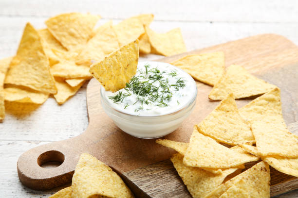 istock Potato chips with sauce and green dill on wooden table 1125581230