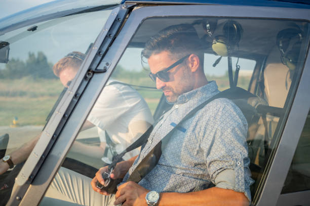 istock Passenger in helicopter cockpit fastening seat belt 1125581238