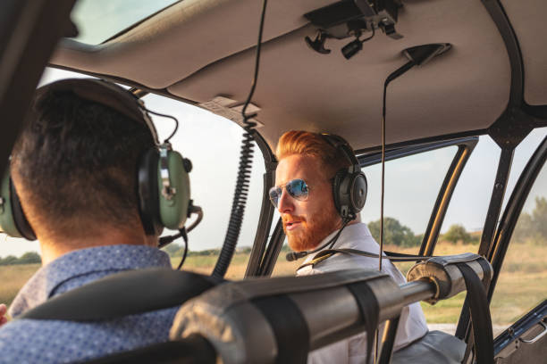 istock Helicopter pilot talking to passenger in the cockpit 1125581346