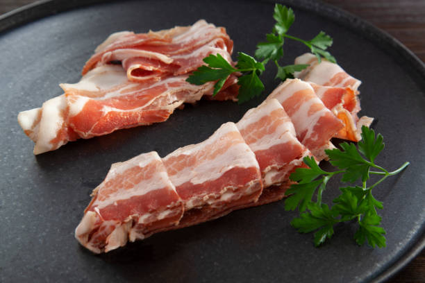 Dry Spanish ham, Italian Prosciutto Crudo or Parma ham Dry Spanish ham, Italian Prosciutto Crudo or Parma ham, cutting  on plate with Italian parsley uncooked bacon stock pictures, royalty-free photos & images