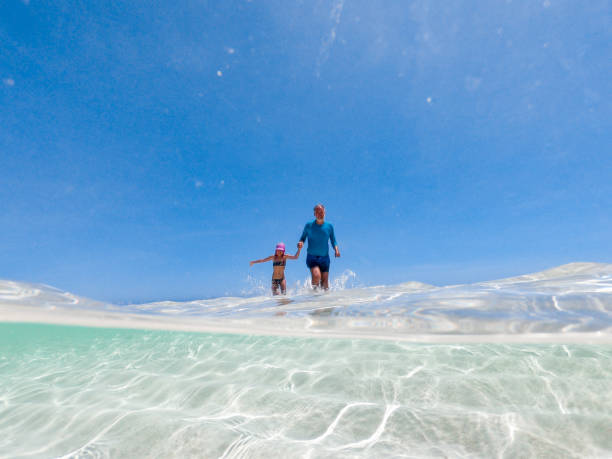 istock Father and Daughter Playing in Clear Shallow Water 1125586209