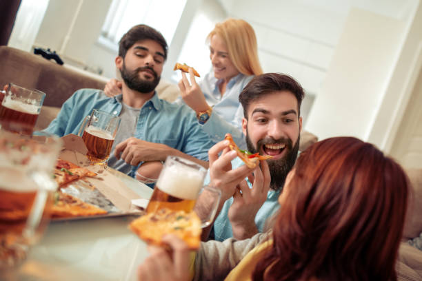 istock Friends watching TV at home while eating pizza 1125587791