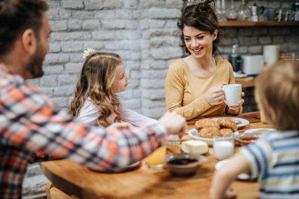 istock Young happy family communicating while having breakfast in dining room. 1125599659