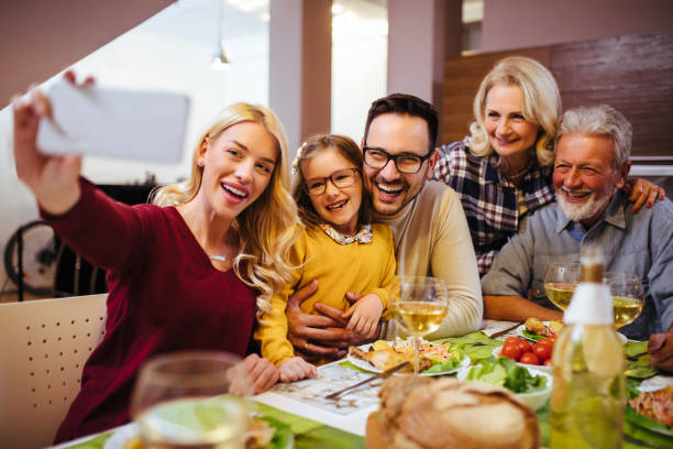 madre che si fa selfie della sua famiglia multi-generazione a casa - wireless technology cheerful granddaughter grandmother foto e immagini stock