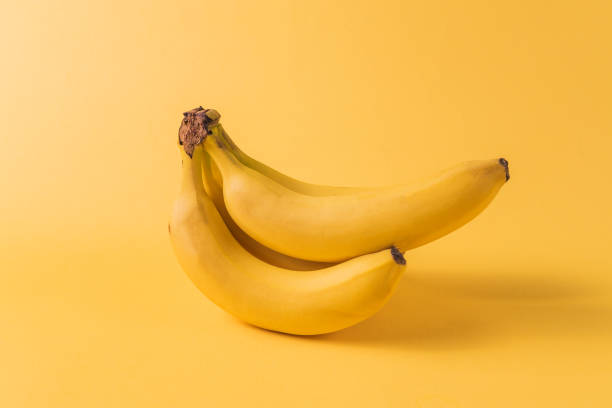 istock Minimalism style. Fruit pattern with yellow ripe banana fruit over yellow background. 1125600931