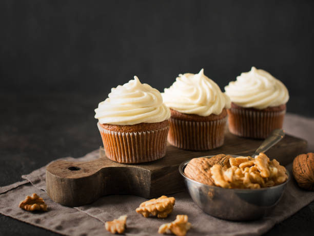 istock Carrot cupcakes or muffins with nuts on dark background 1125602609