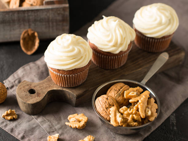Carrot cupcakes or muffins with nuts on dark background, copy space